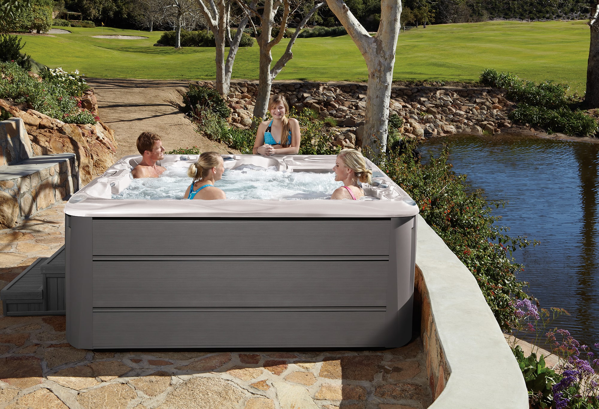 Family enjoying their Sundance Spas 880 Series Cameo by the water